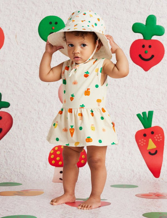 Child wearing a singlet dress with veggie print design