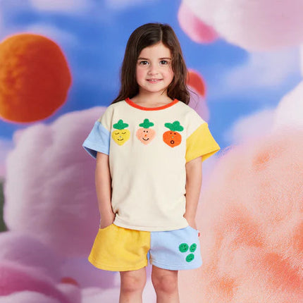 Young girl wearing a colorful outfit with a floral background